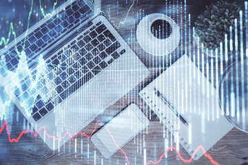 Financial market graph and top view computer on the desktop background. Double exposure. Investment concept.