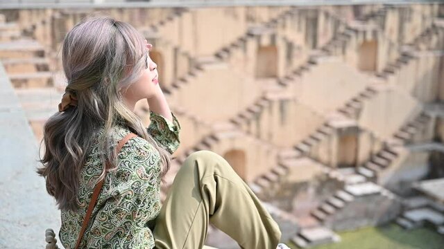 Portrait of Asian woman traveling in stepwell in India 