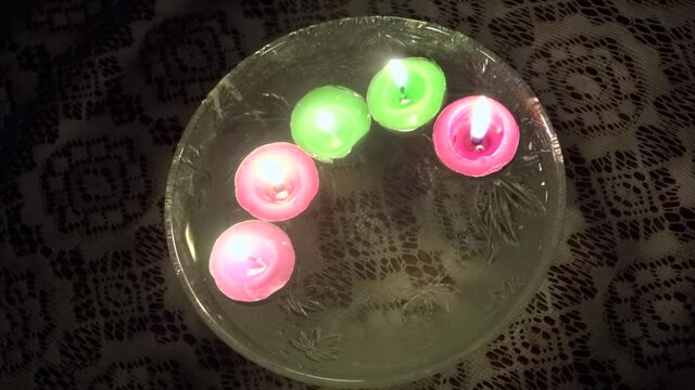Close-up, high angle, colored tea lights floating in water, India