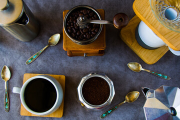 Coffee makers and beans, cup of coffee and spoons