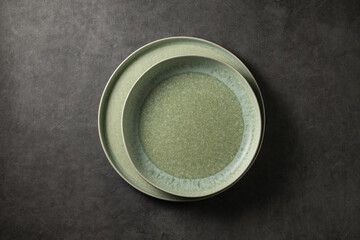 two beautiful modern plates on a dark gray concrete background, top view
