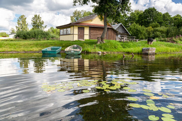 Obraz premium Plastic fishing boats and wooden bath at the bank of the lake