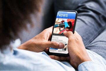 African American Holding Mobile Phone Reading News