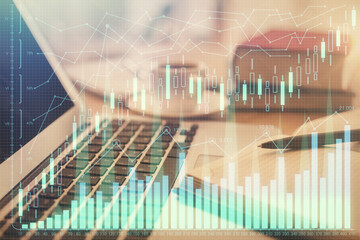 Double exposure of financial chart drawing and desktop with coffee and items on table background. Concept of forex market trading