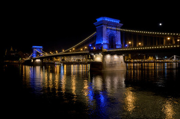 Fototapeta na wymiar The famous Chain bridge with the illuminated city in the background at night, Budapest, Hungary