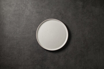 beautiful modern plate on a dark gray concrete background, top view