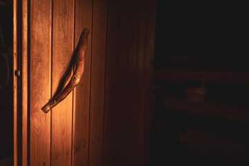 Traditional wooden sauna door handle close-up