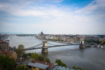 Fototapeta premium Budapest city landscape with the famous Chain bridge over the Danube river and the Parliament building in the background on a cloudy day, Budapest, Hungary