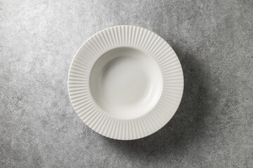 beautiful white plate on gray concrete background, top view