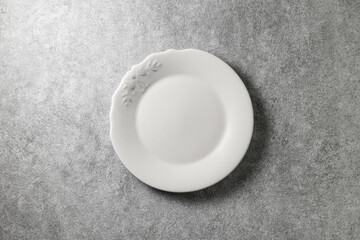 beautiful vintage plate on gray concrete background, top view 