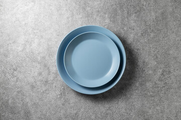 two beautiful blue plates on a gray concrete background, top view
