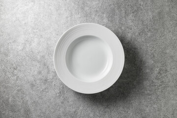 beautiful white plate on gray concrete background, top view