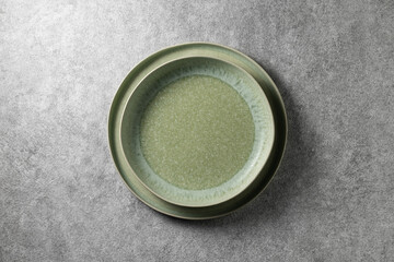 two beautiful green plates on a gray concrete background, top view
