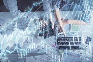 Multi exposure of man and woman working together and forex graph hologram drawing. Financial analysis concept. Computer background. Top View.