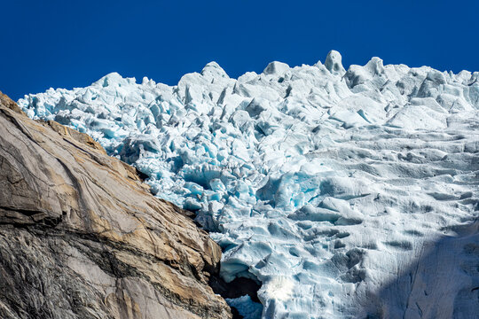Sichtbarer Klimawandel in Norwegen: Nahaufnahme / Tele des sich zur&uuml;ckziehenden Gletscher Briksdalsbre N&auml;he Oldens mit blauem Eis