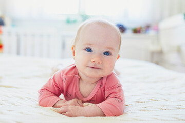 Baby girl relaxing in bedroom