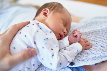 Newborn baby girl sleeping on her father's chest