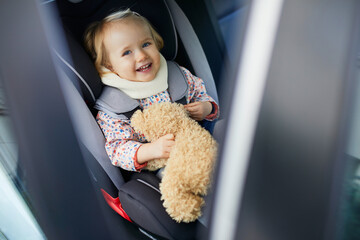 Adorable toddler girl in modern car seat