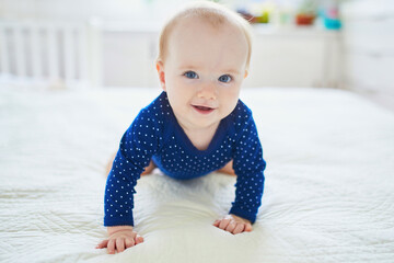 Baby girl crawling on bed