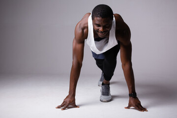 African american man standing in low start pose on white background