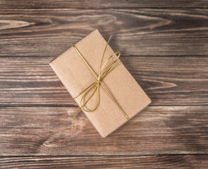 
Gift box in craft paper on a wooden background.
