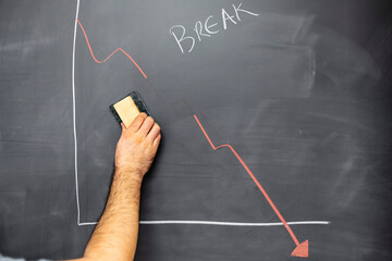 hand breaking the downward trend of a graph in crisis