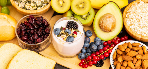 Group Fruits Breakfast with bread Whole grains and nuts, yogurt mix with Cherry , banana, avocado in the wooden table. Breakfast for Health and Diet concept