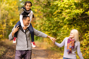Fototapeta premium happy family Walking through autumn park