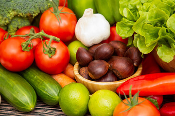 Group vegetables and Fruits Apples, grapes, oranges, pineapples, bananas in a wooden basket with carrots, tomatoes, guava, chili, eggplant, golden pod, green salad on wooden table.