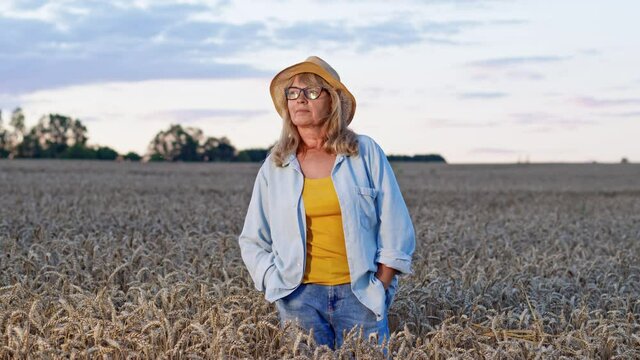 Image Of Conceived Middle Aged Woman In Wheat Field. She Stands And Looks Into The Distance.