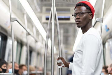 Afro American man in red hat does not want to wear a face mask in public transportation during...