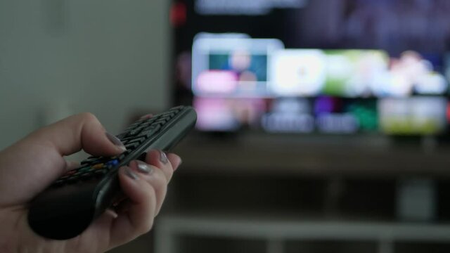 Person choosing the movie on the online movie platform in the living room of his home