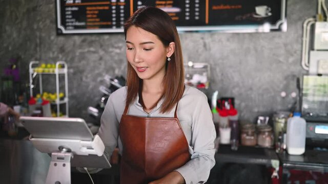 Portrait of Asian barista working in her small coffee shop. New normal startup small business