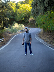Hombre caminando por una carretera usando mascarilla
