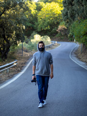 Hombre caminando por una carretera usando mascarilla