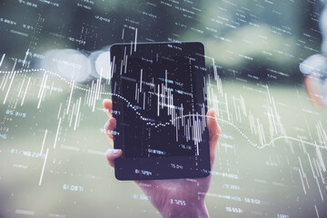 Double exposure of forex chart sketch hologram and woman holding and using a mobile device. Financial market concept.