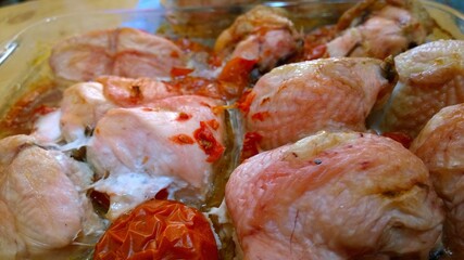 Baked chicken legs in a broth with tomatoes. Delicious homemade ham in the oven. Crispy dinner. Healthy eating and immunity support. Simple recipe. Wholesome food. Home cooking. Selective focus.