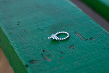 silver baby ring on green board