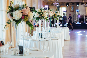A beautiful vase of flowers on a table in a luxury restaurant. Wedding decorations