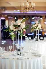 A beautiful vase of flowers on a table in a luxury restaurant. Wedding decorations