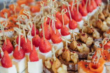 Sandwiches, canapes and cakes on the festive table. A wide variety of snacks