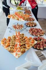 Sandwiches, canapes and cakes on the festive table. A wide variety of snacks
