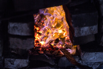 In a blacksmith's workshop. The metal billet is held in a coal flame in a furnace. An example of the hard work of ancient crafts.