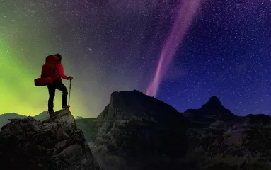 Fotobehang Girl Hiking on top of Rocky Mountains with backpack. Dreamscape Adventure Composite. Night Sky with Stars and Aurora Northern Lights. Concept: Freedom, Explore, Travel, Fitness © edb3_16