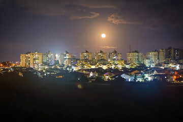 Moon over the night city. Ashkelon, Israel