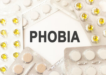 Text phobia on white background. There are various pills and vitamins around. Medical concept