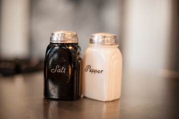 Closeup of vintage black and white glass salt and pepper shakers.