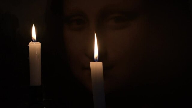 Face of Mona Lisa o Gioconda illuminated with candles