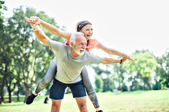 outdoor senior fitness woman man lifestyle active sport exercise healthy fit retirement love fun piggyback