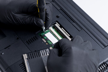 close up view for a technician worker repairing or adjusting laptop pc. person using work tool to open memory module socket. laptop and computer service conceptual